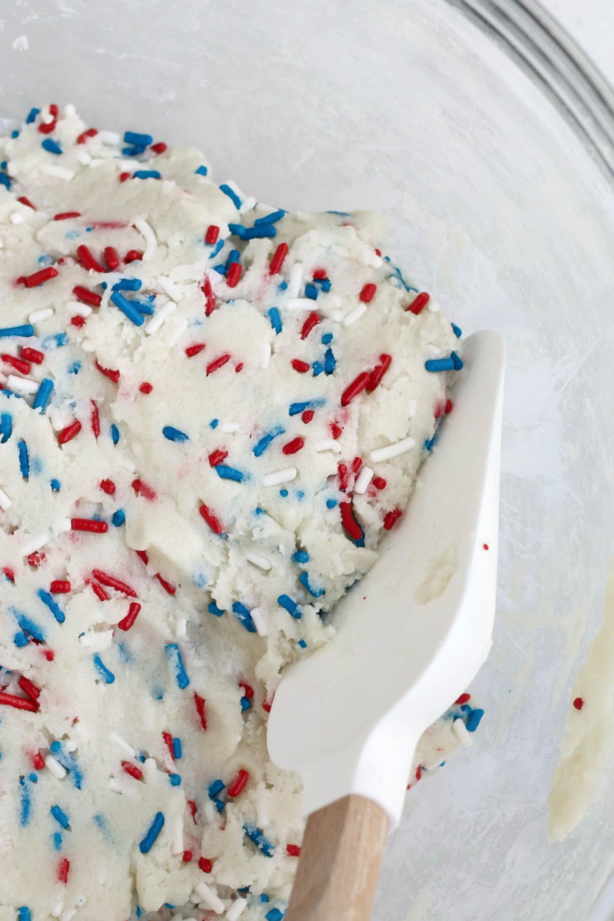 Mixing the wet and dry ingredients together with the red, white and blue sprinkles.