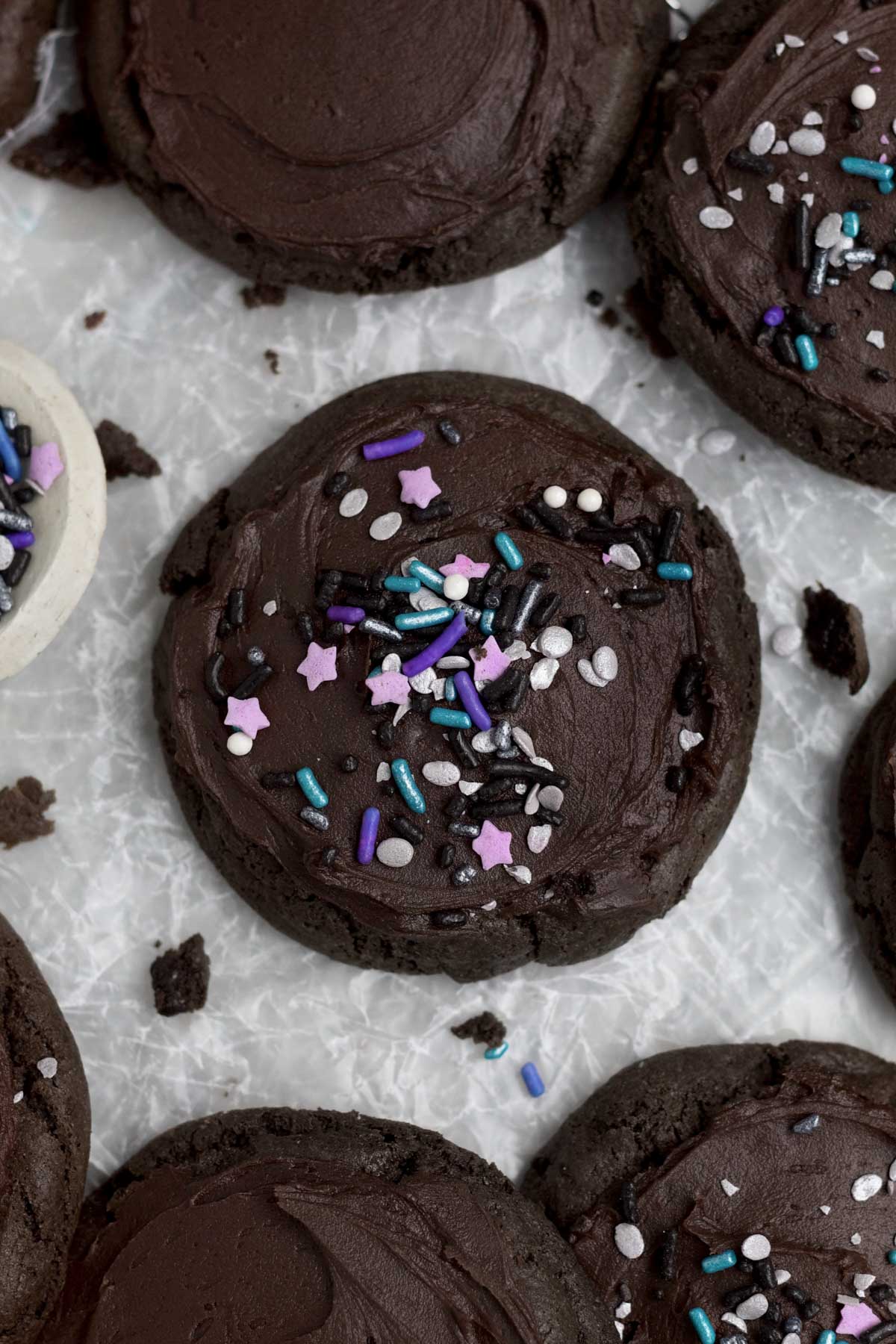 Lavender stars and purple and periwinkle rod sprinkles decorate the top of the frosted chocolate cookies.