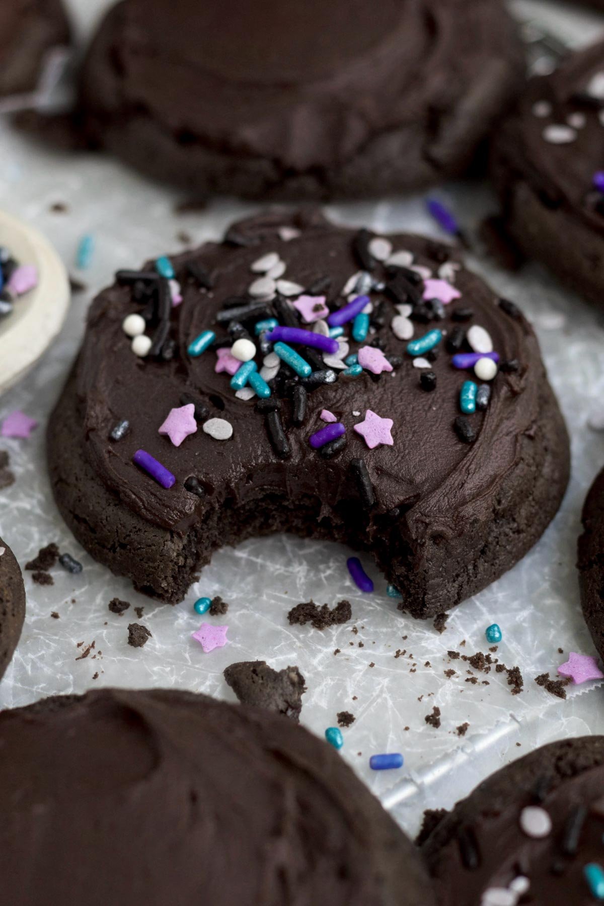 A bite reveals the warm delicate interior of the rich chocolate frosted cookie.
