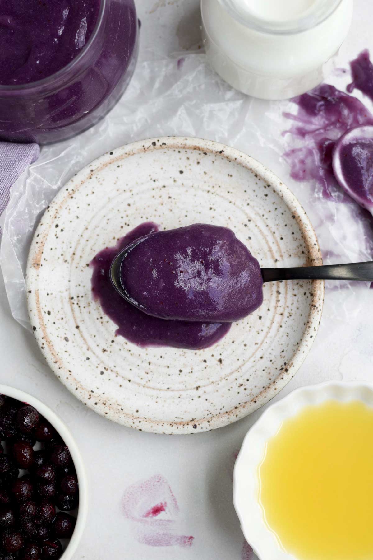 A healthy dollop of Blueberry Curd on a spoon ready to be enjoyed.