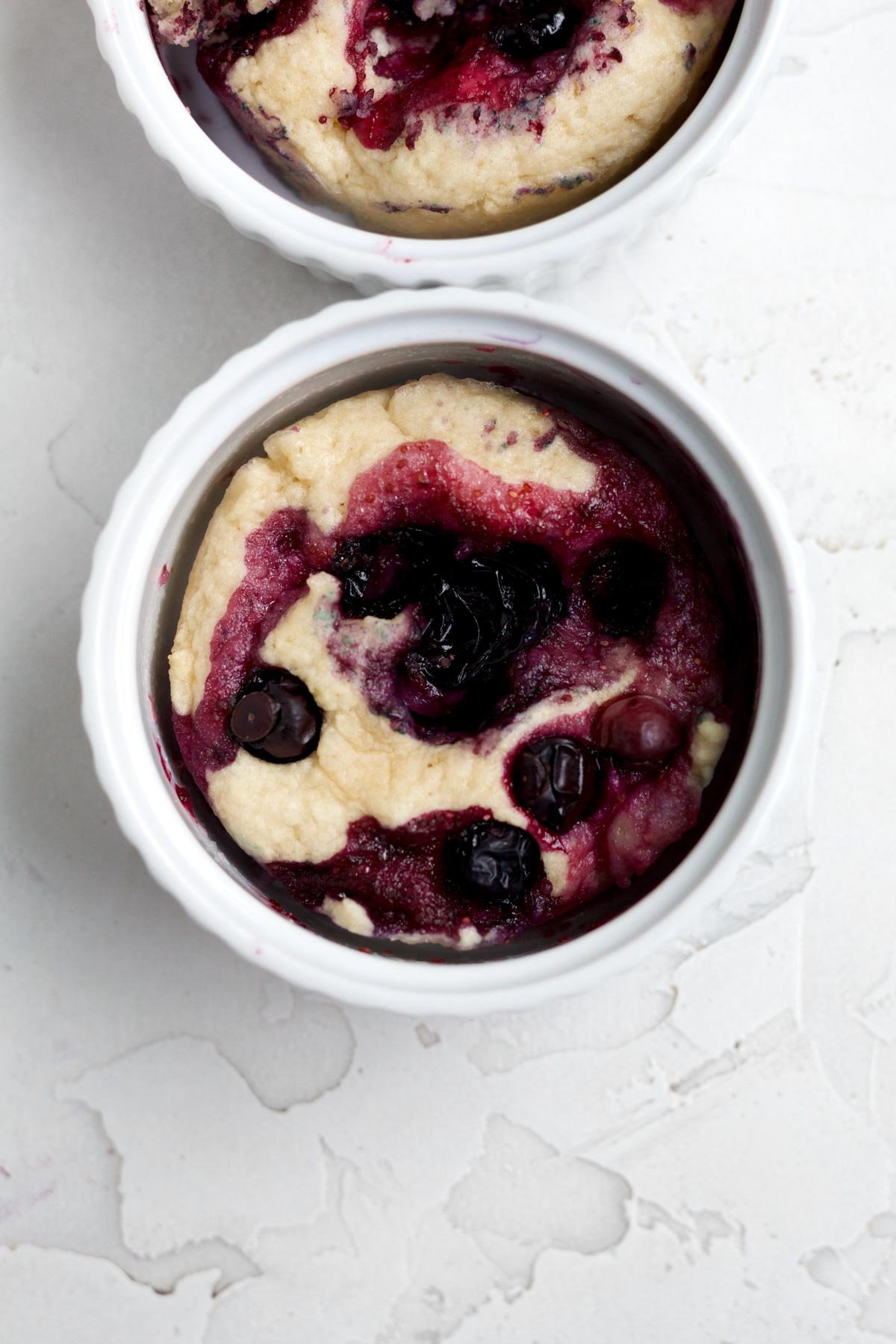 Warm baked blueberry mug cake oozing with purple blueberry juice.