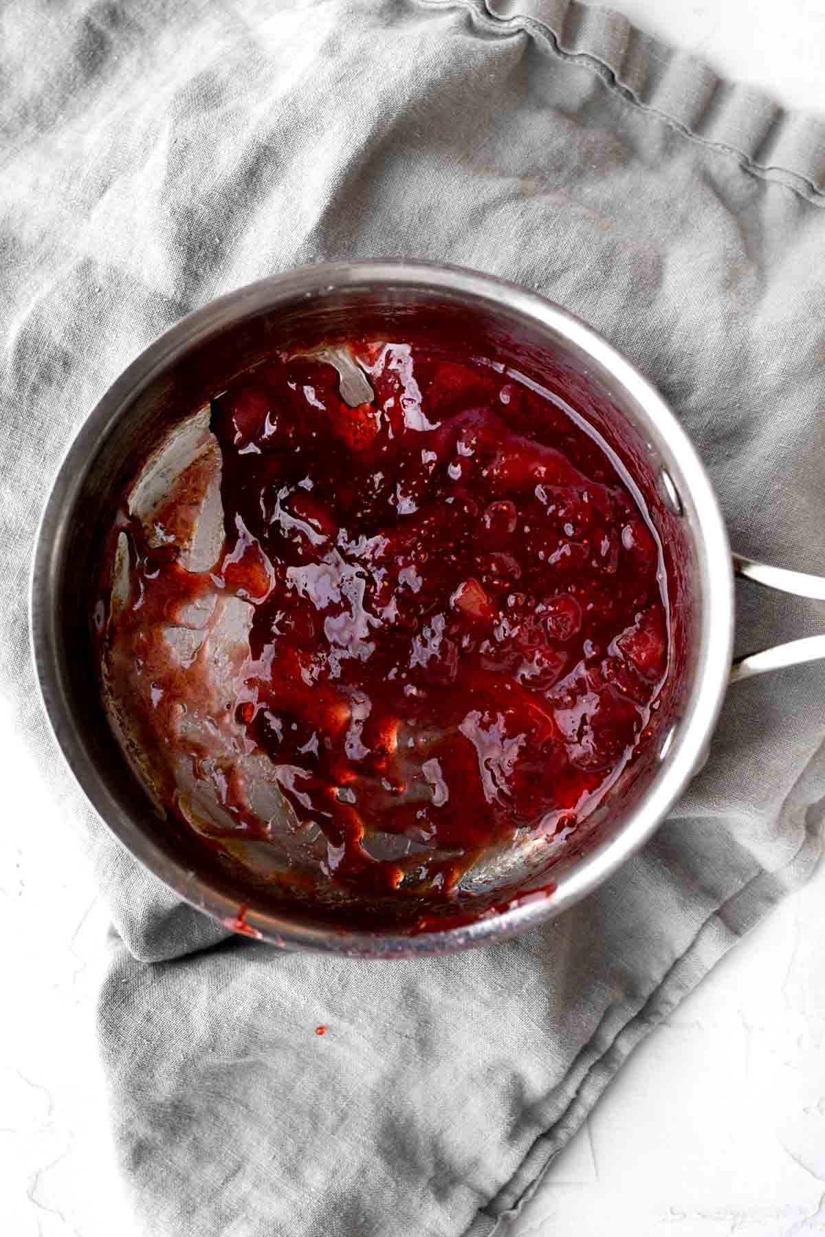 Sugar and strawberries simmering in a saucepan.