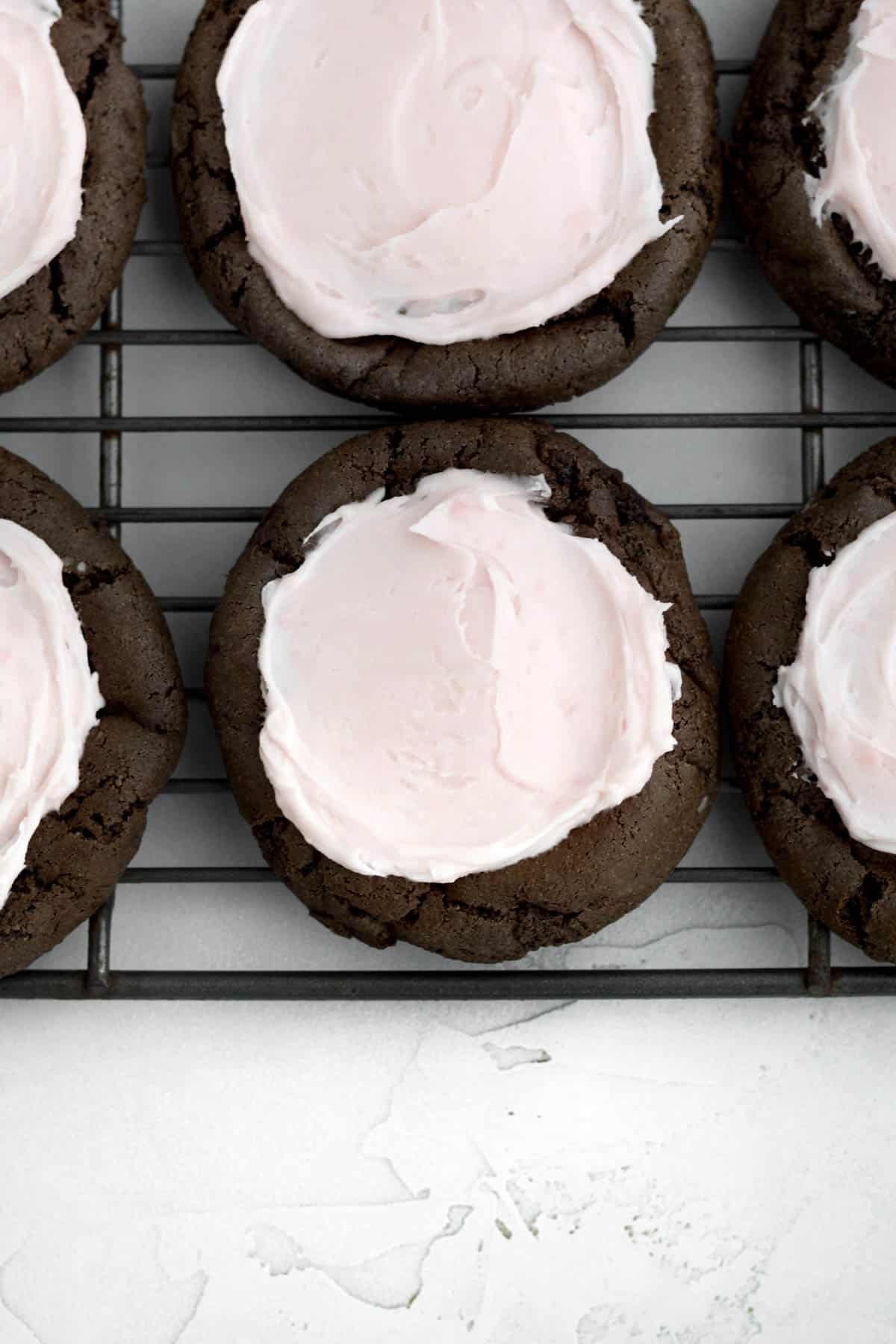 Spreading the strawberry frosting on the cookie bases.