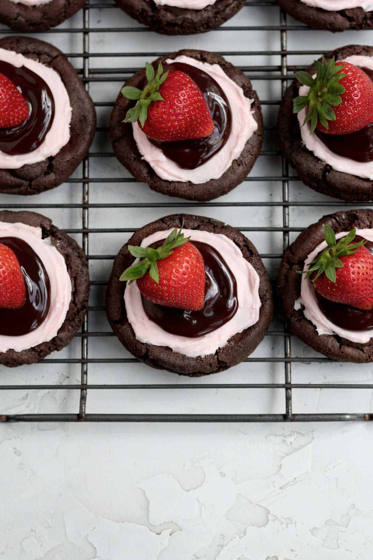 Adding a dollop of ganache and garnishing the cookie with a whole strawberry