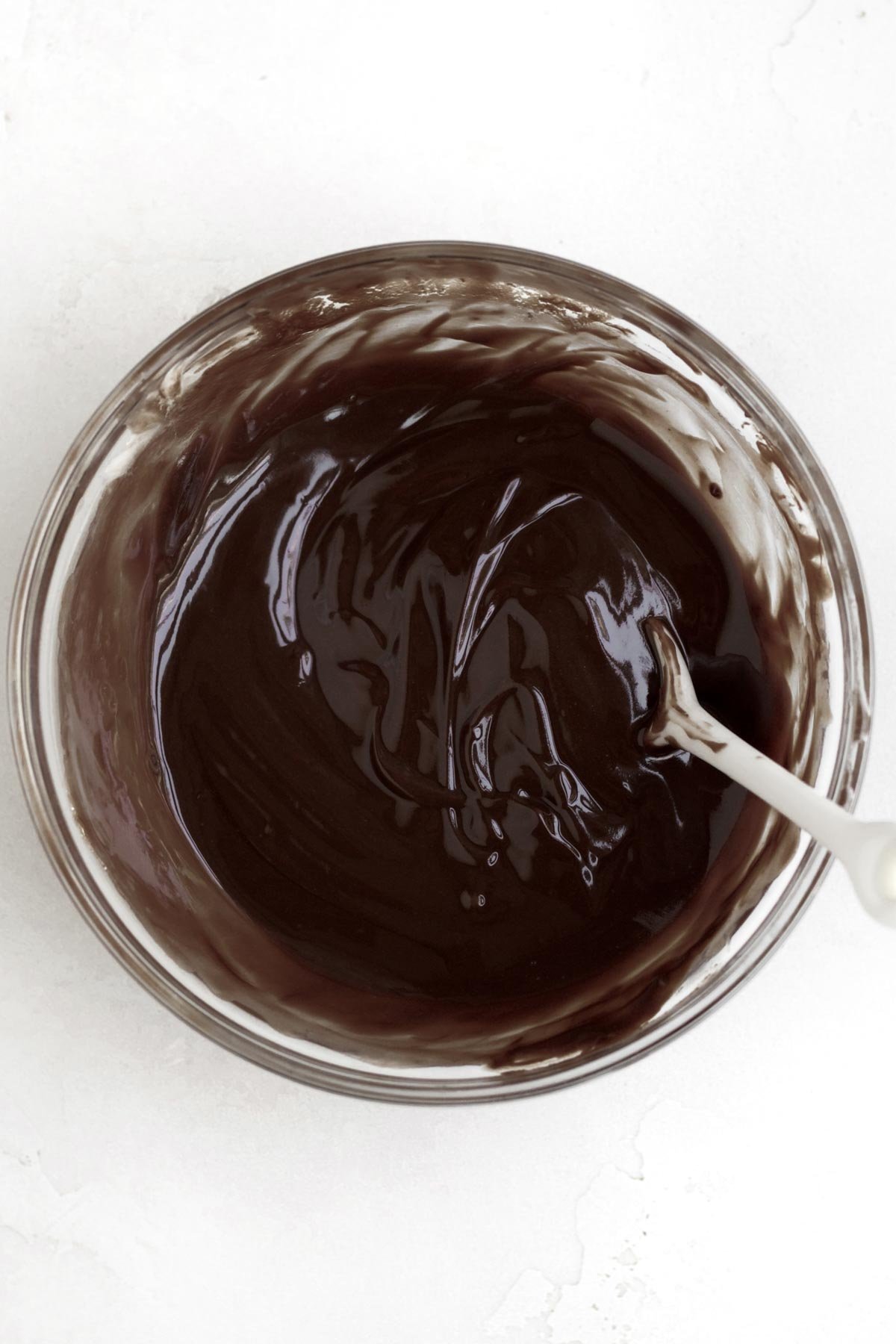 Mixing chocolate and butter into a chocolate drizzle.