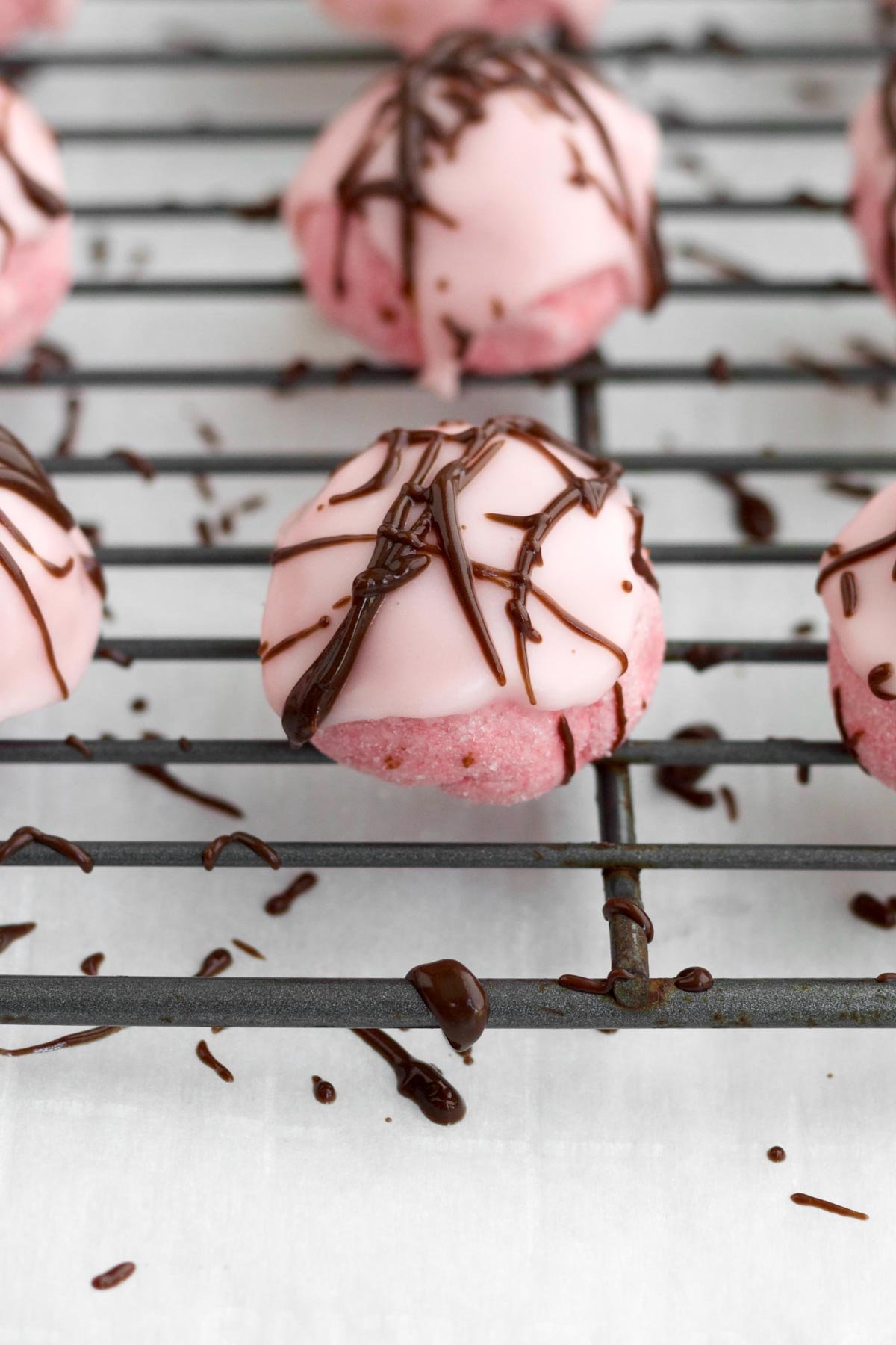 Drizzling the chocolate on top of the glazed Strawberry Shortbread Cookies.