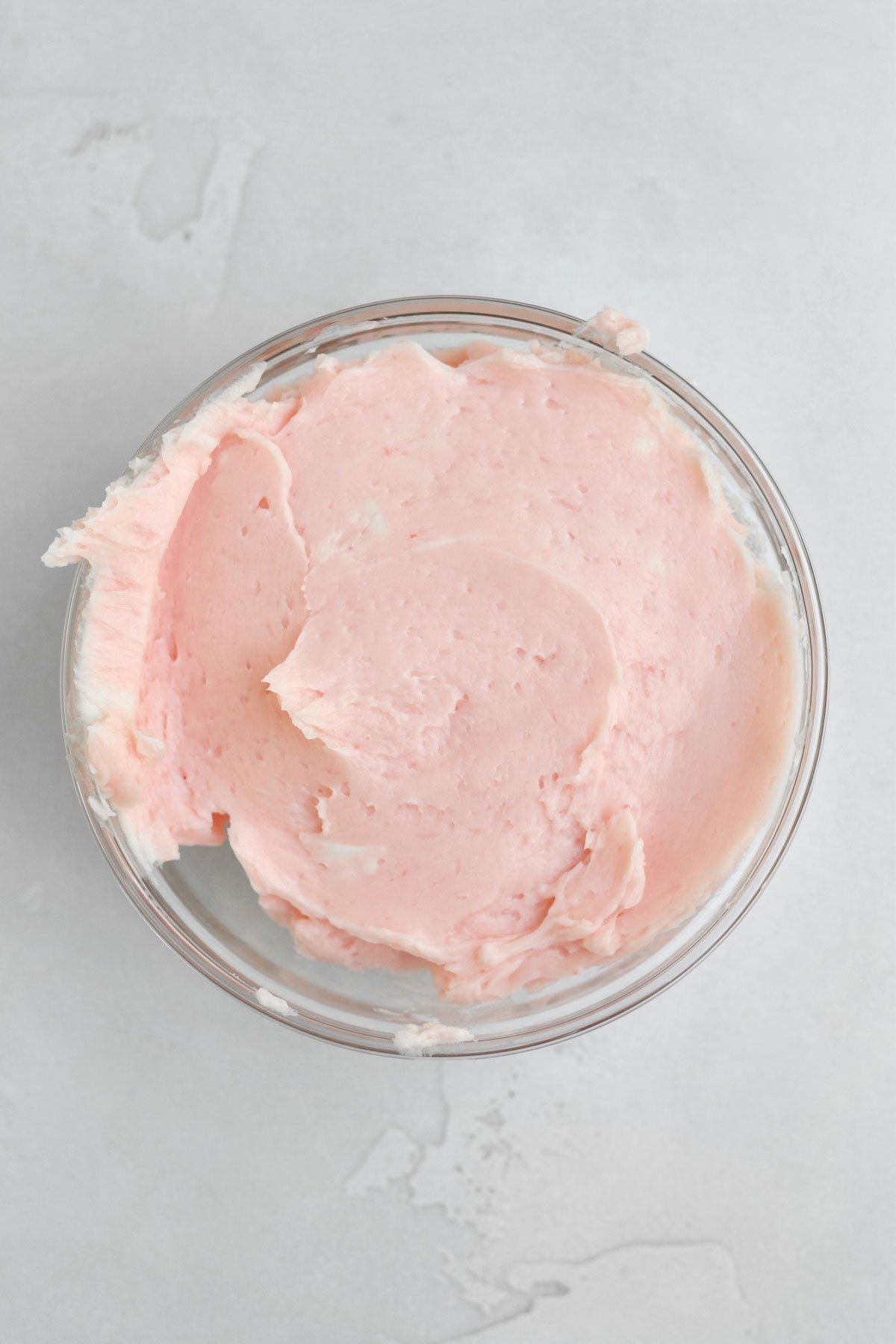 Mixing the wet ingredients and some strawberry liquid into creamed butter and sugar.