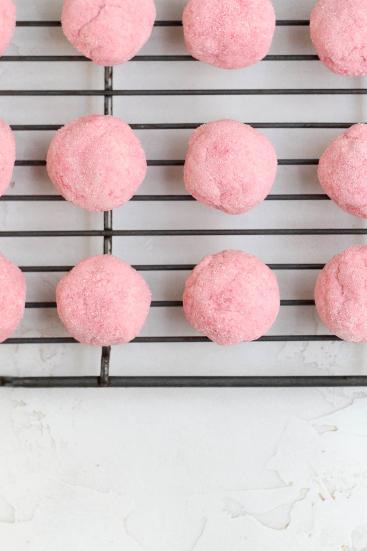 Warm fresh baked Strawberry Shortbread Cookies resting on a cooling rack.