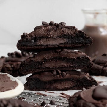 A trio of stacked Chocolate Cheesecake Cookies stuffed with sugary goodness.