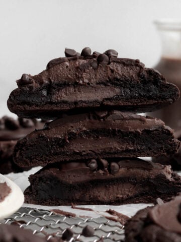A trio of stacked Chocolate Cheesecake Cookies stuffed with sugary goodness.