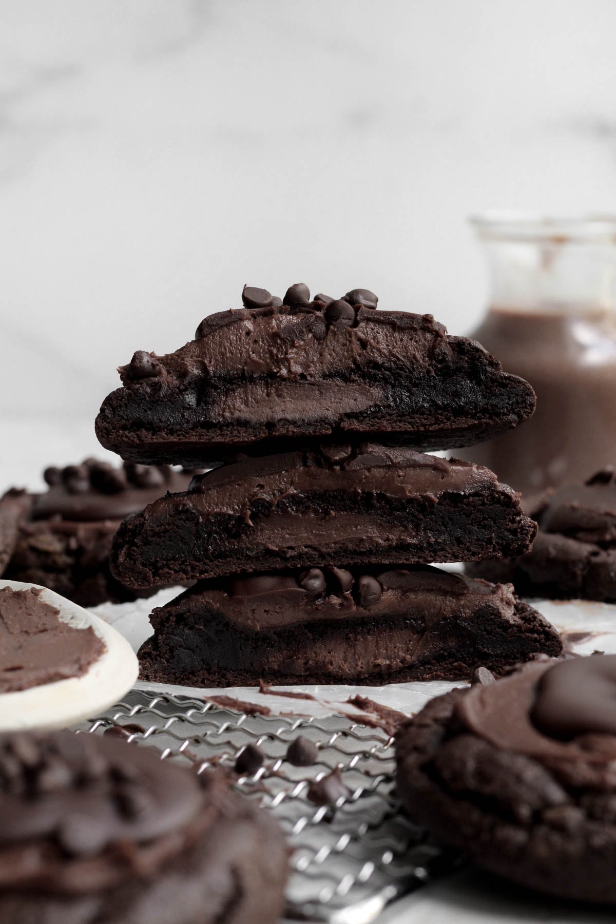 A trio of stacked Chocolate Cheesecake Cookies stuffed with sugary goodness.