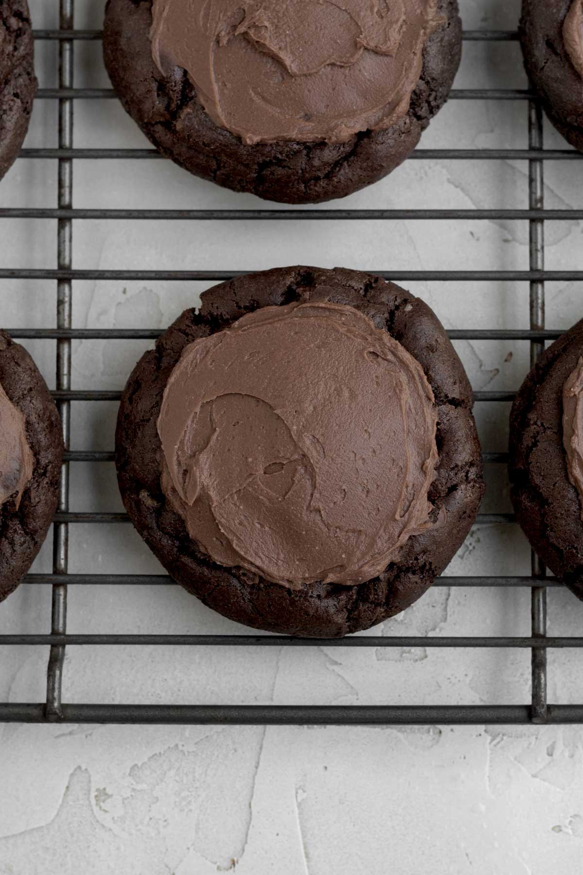 Topping the cookie with more rich cheesecake filling.