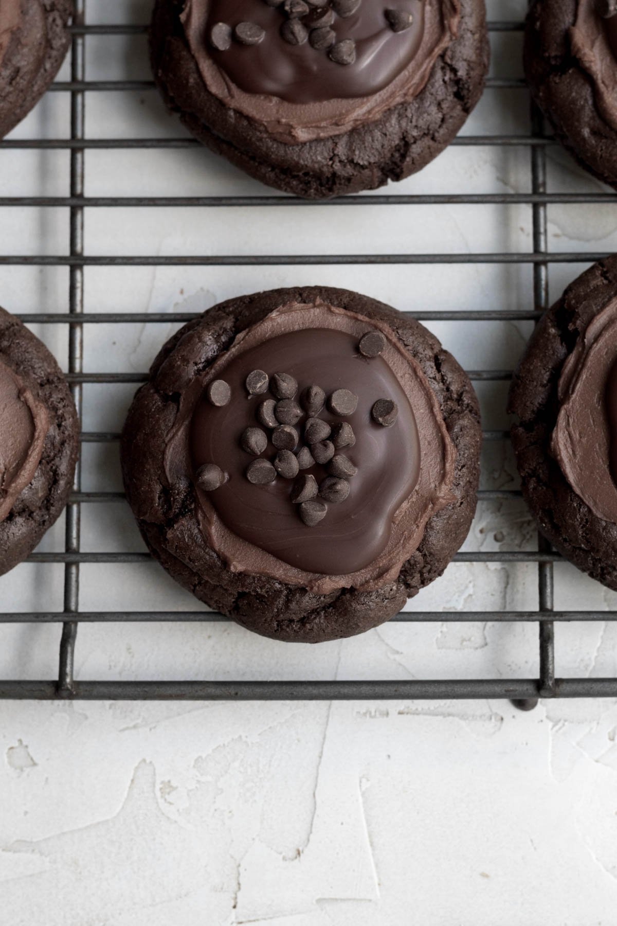 Topping the cookie with ganache and mini chocolate chips.