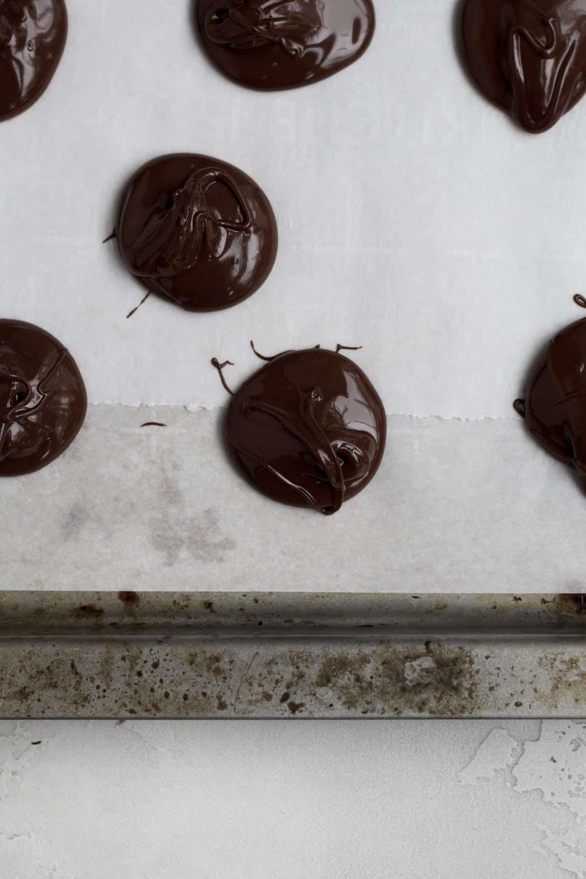 Dollops of chocolate on parchment paper.