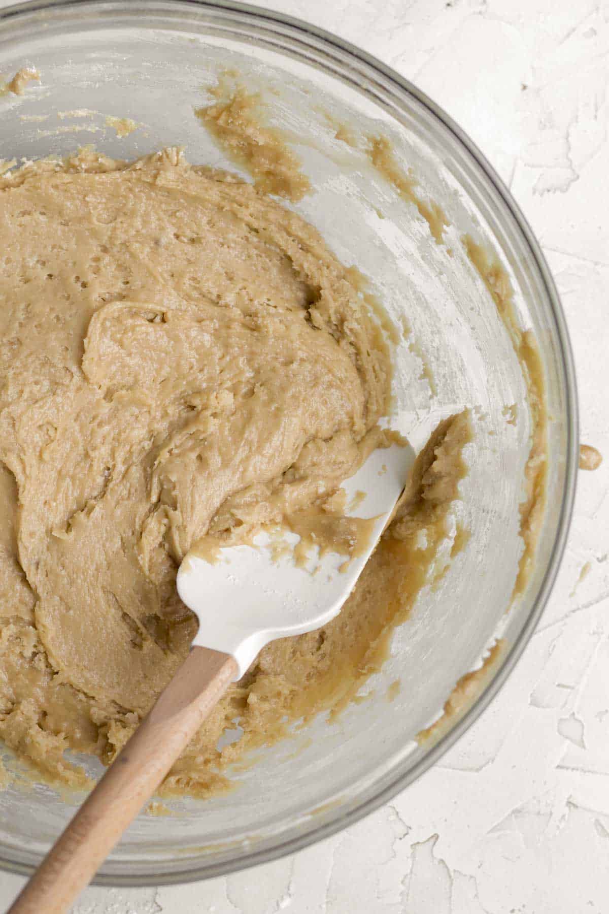 Mixing the wet and dry ingredients with a spatula.