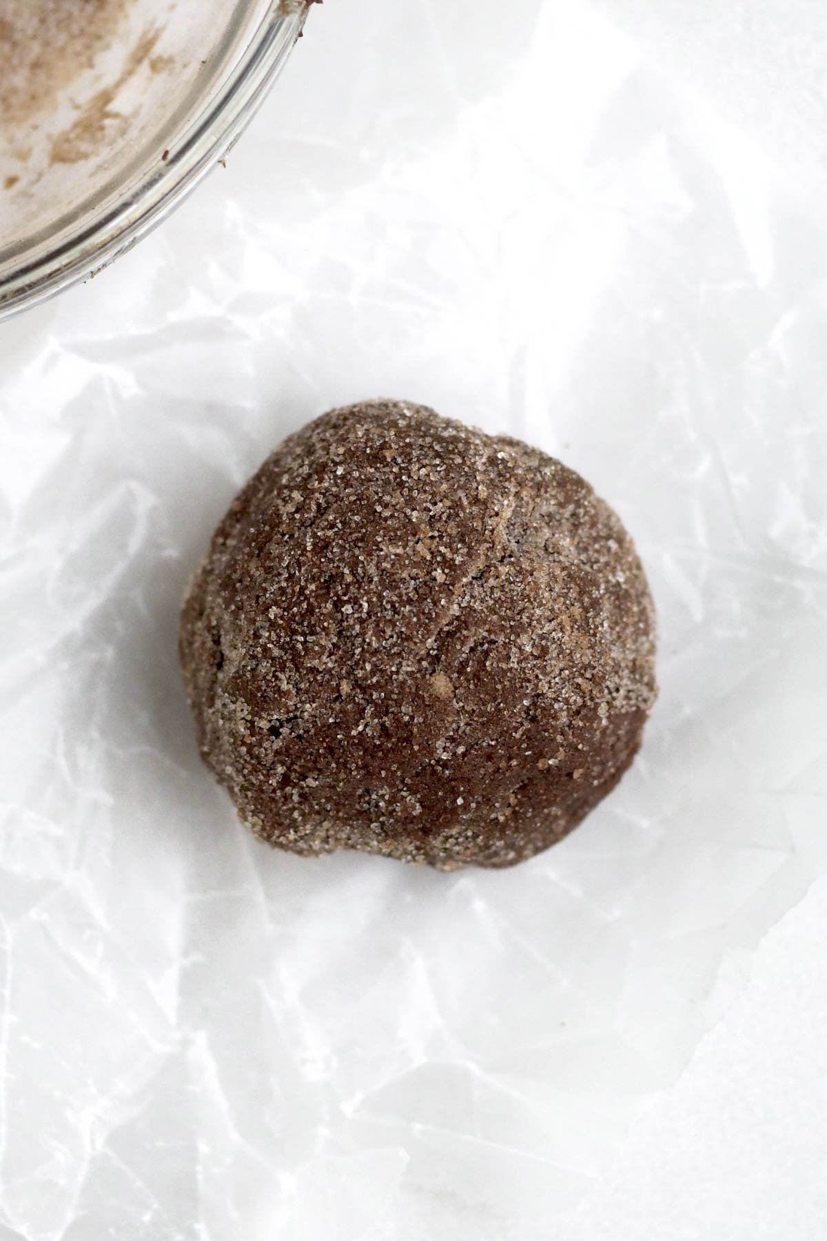 A Scooped ball of Cinnamon Chocolate Cookie Dough in Cinnamon Sugar.