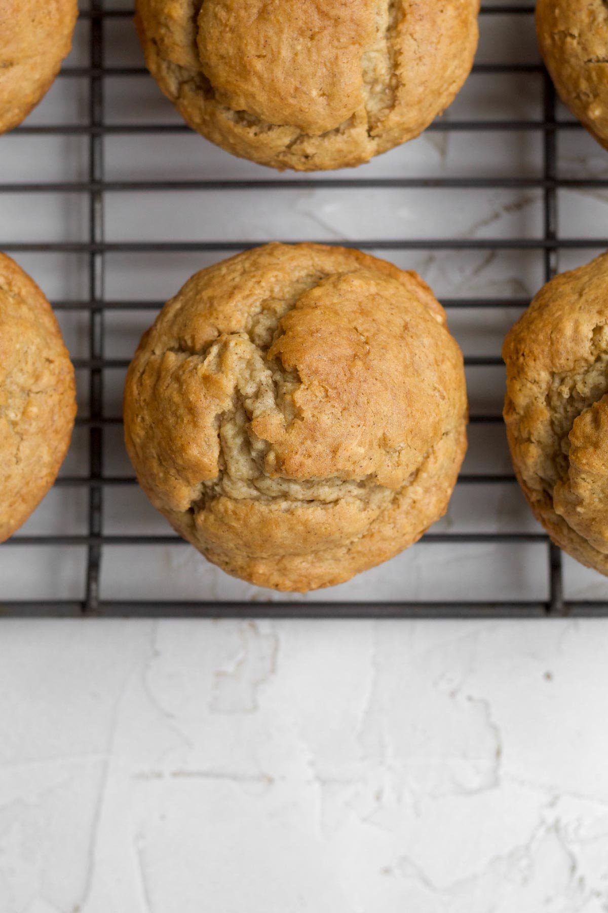 Fresh baked, warm gluten free applesauce muffins on a cooling rack.