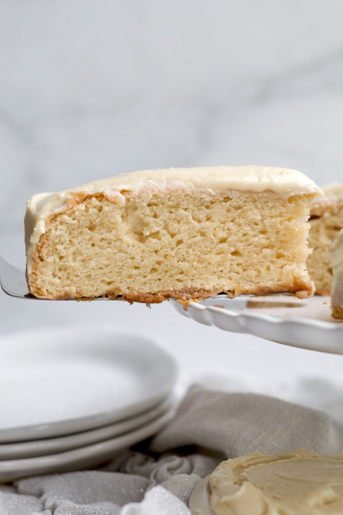 A slice of light and airy Maple Cake pulled from the whole.