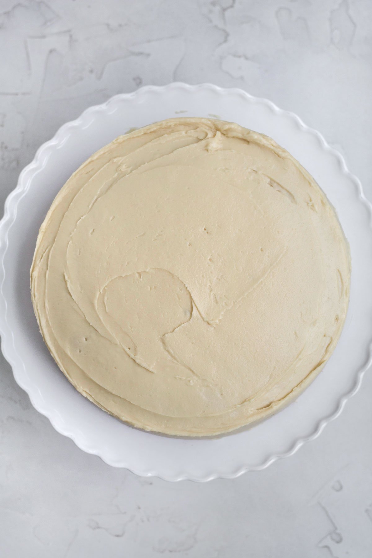 Frosting the cake with the creamy maple frosting.