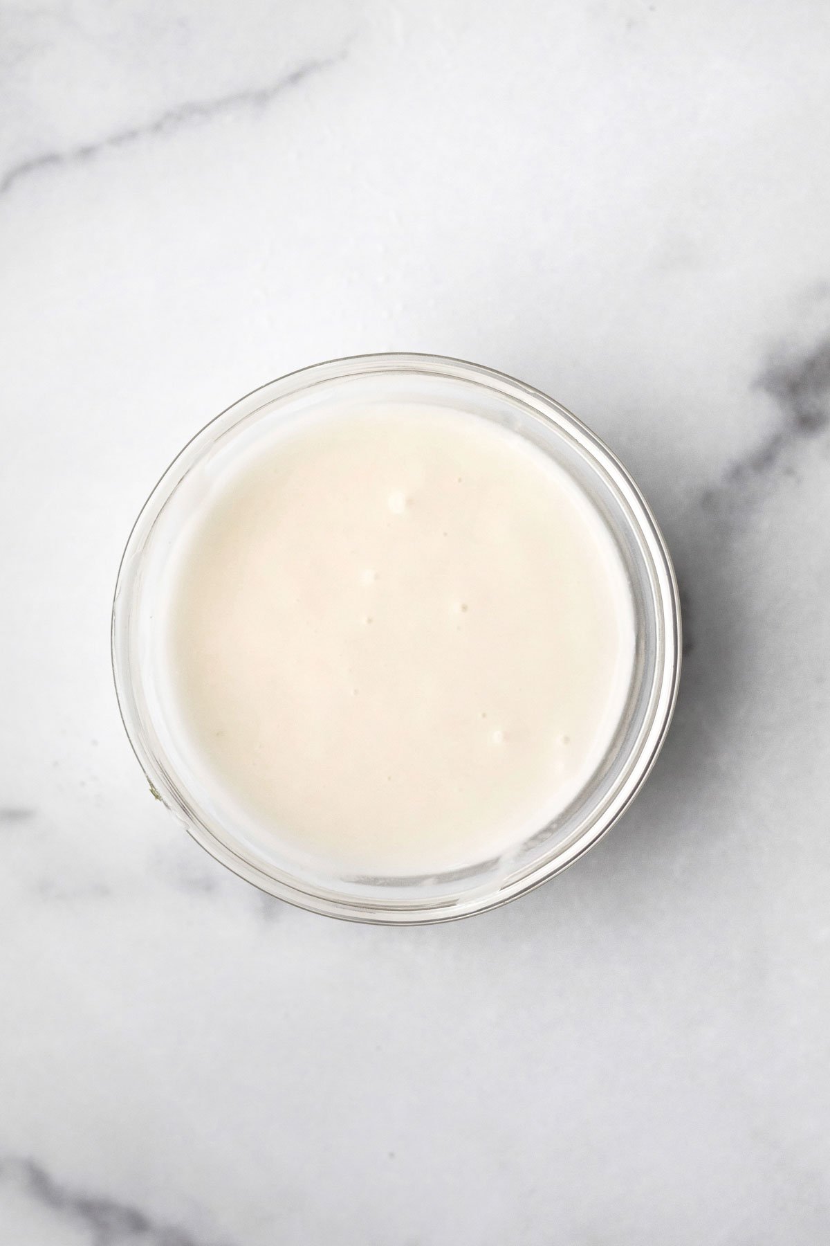 A bowl of sugary cream cheese glaze.