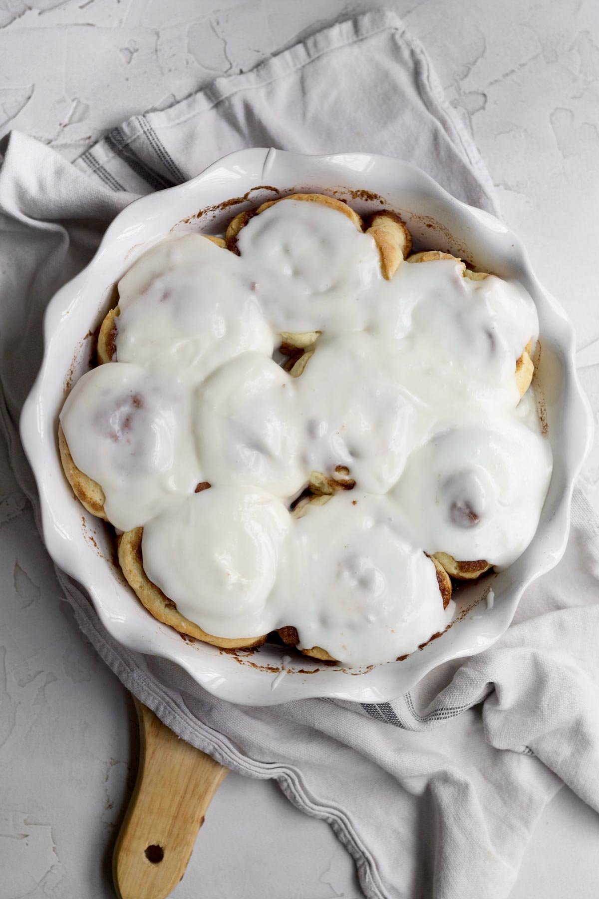 Topping the No Yeast Cinnamon Rolls with the sugary Glaze.