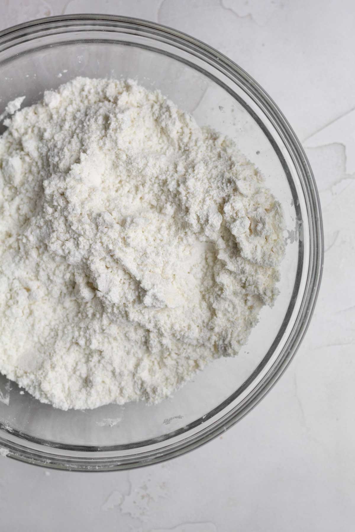 Adding crumbled butter into the ingredients.