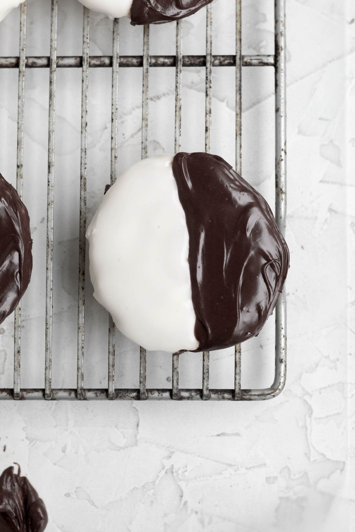 Spreading the sweet chocolate icing evenly on the other half of the NYC cookie.