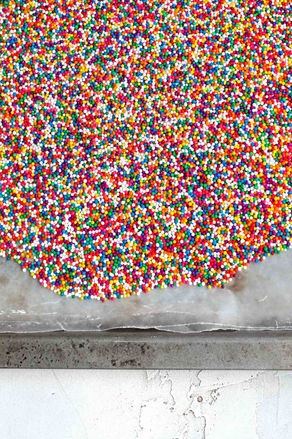 Bright rainbow nonpareils on wax paper.
