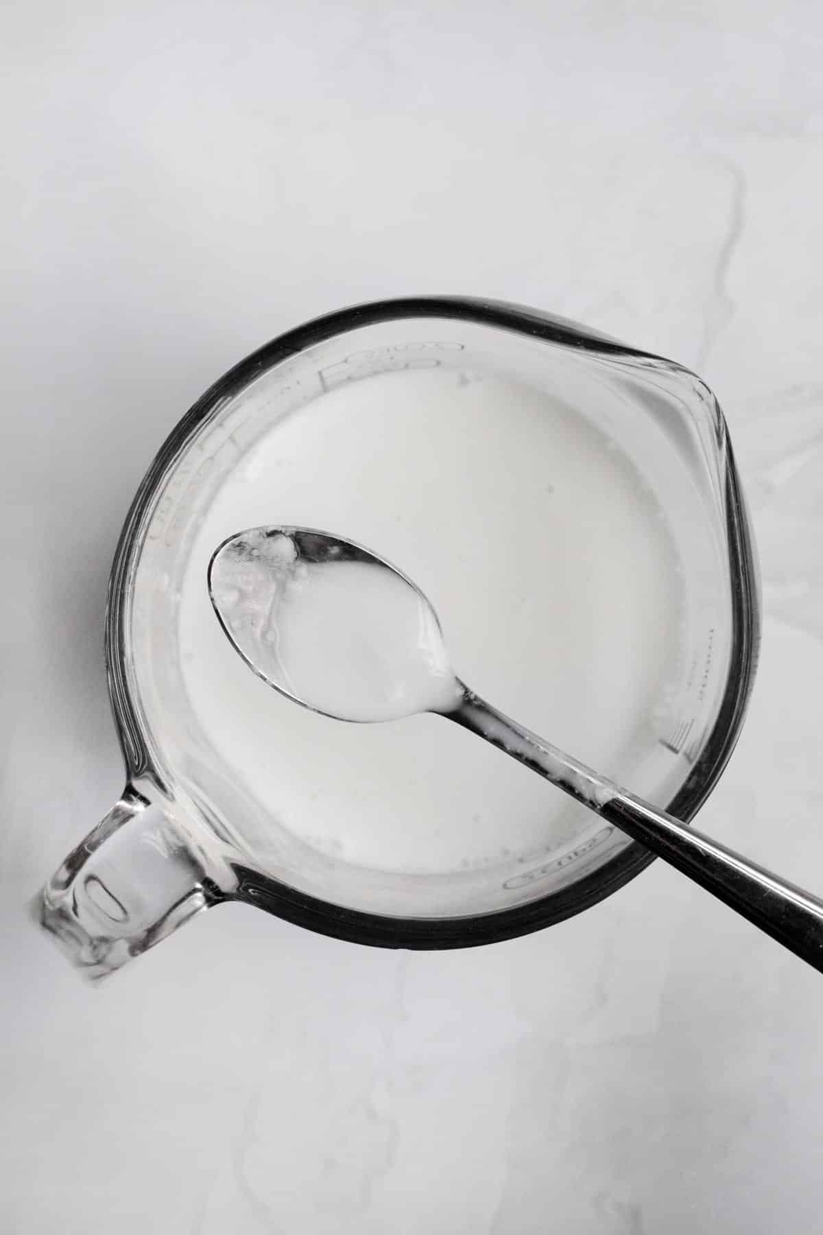 Homemade buttermilk in a measuring cup.