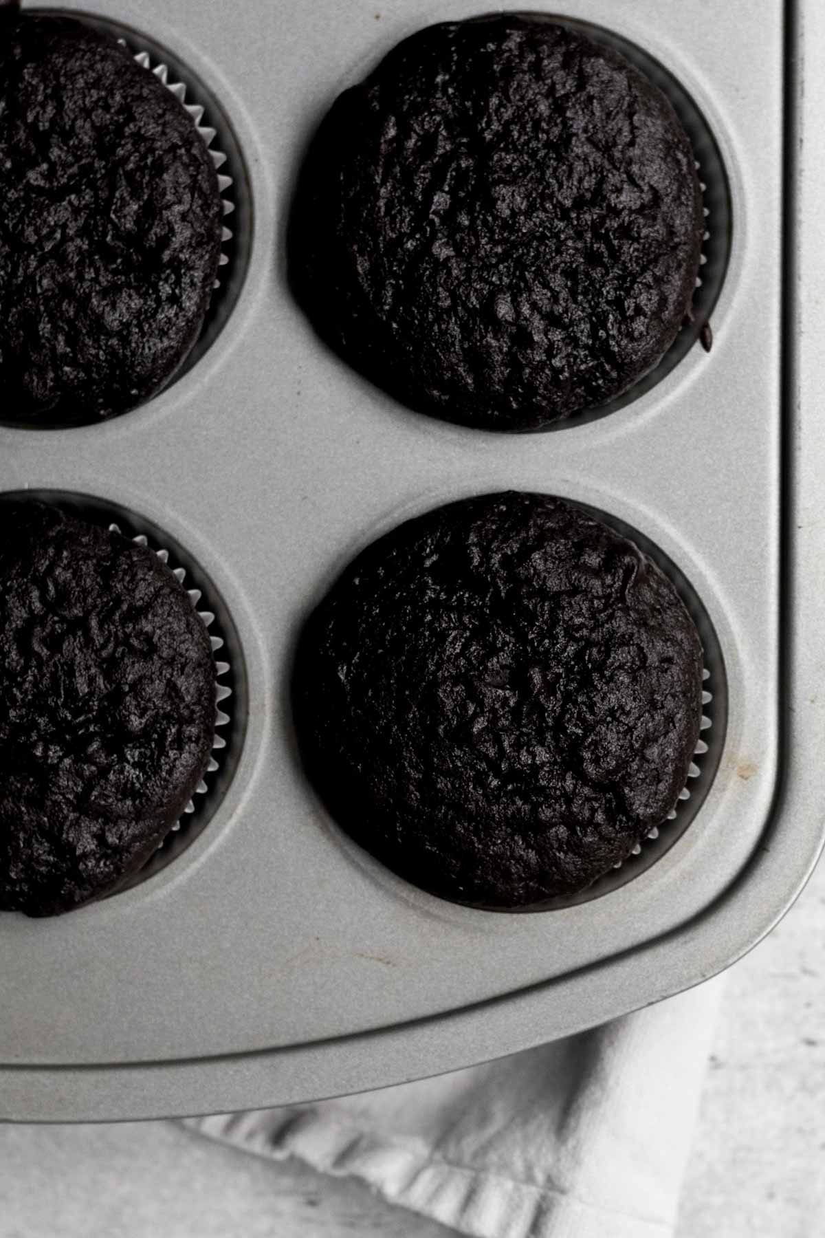 Baked risen chocolate cupcake bottoms in the tin.
