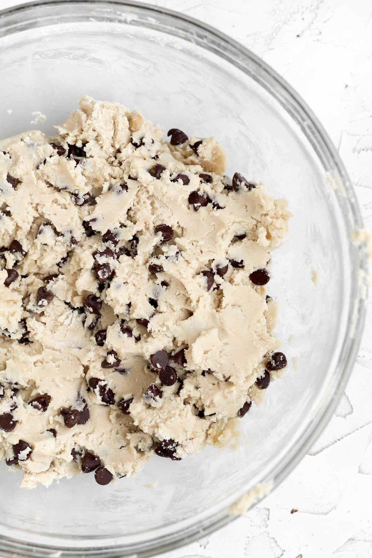 light brown chocolate chip cookie dough batter mixed in a bowl.