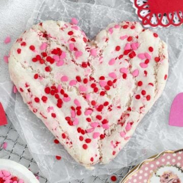 Thick Valentine's Day Sugar Cookie topped with festive pink and red heart sprinkles.