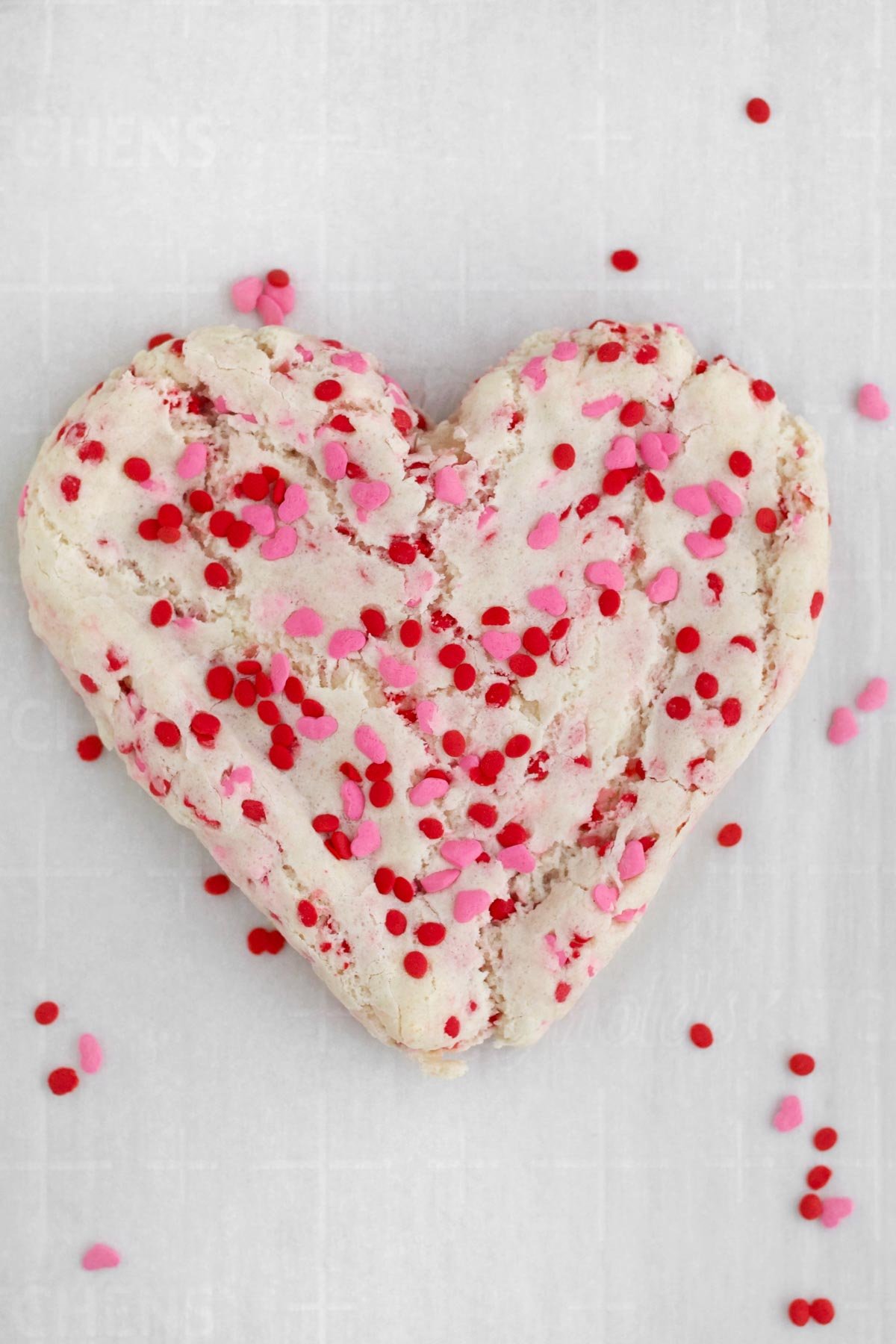 Fresh baked gluten free Valentines Day Sugar Cookie resting on parchment paper.