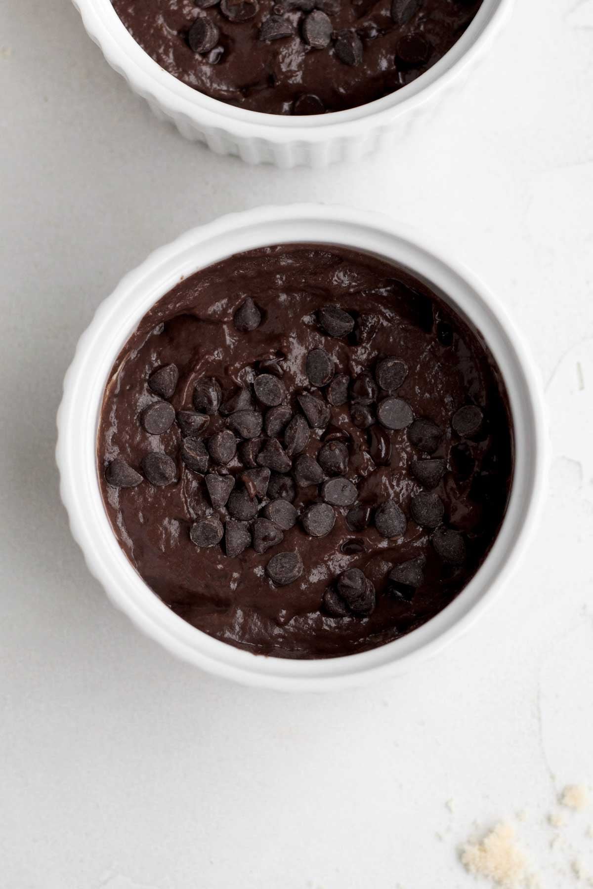 filling ramekins with the batter and adding extra chocolate chips to the top.