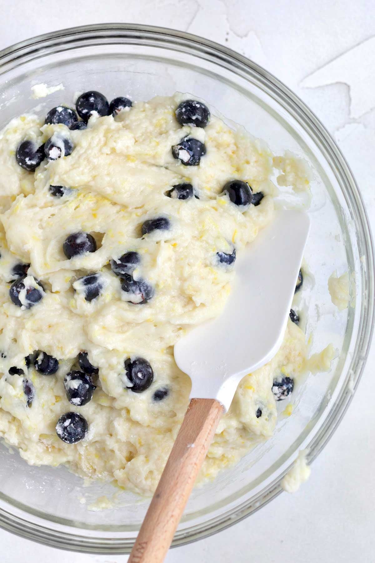Mixing in delicious fresh blueberries to the batter.