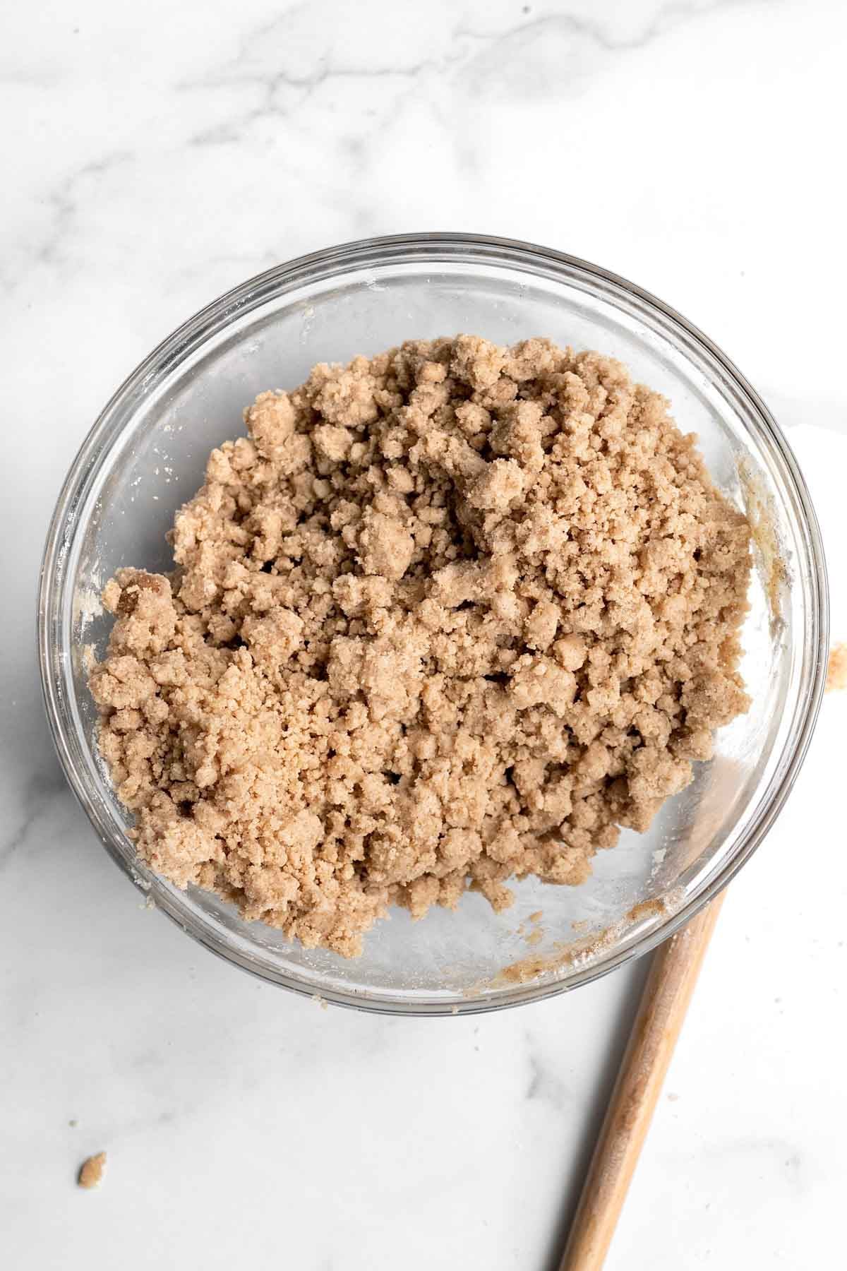 Crunchy and buttery crumbs in a bowl with a spatula.