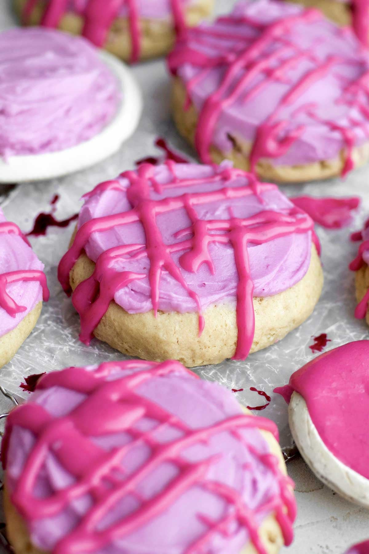 gluten-free brown sugar cookies smothered in blueberry cream cheese frosting and vibrant pink sugary glaze,