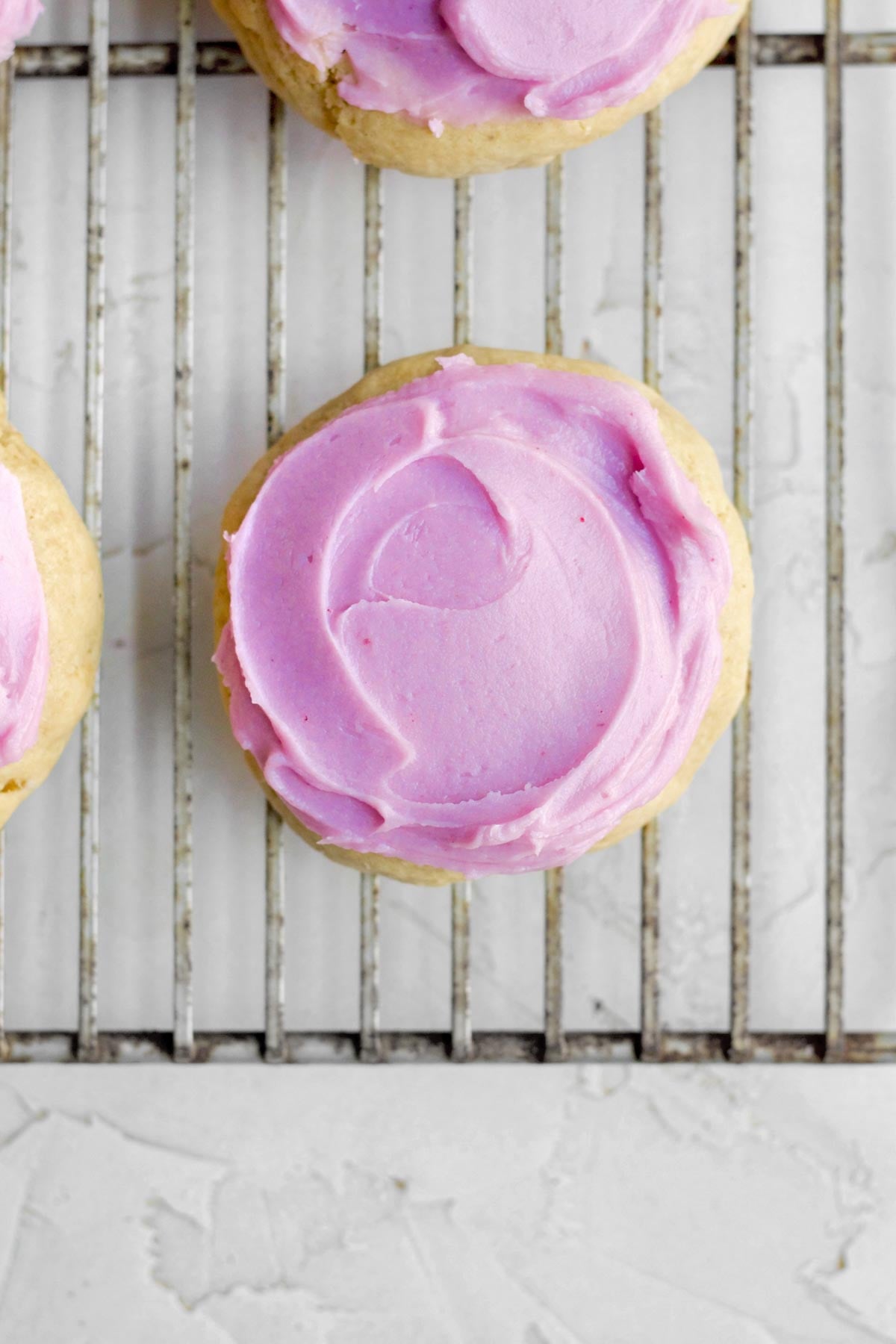 a swirl of blueberry cream cheese frosting the tops of the brown sugar cookies.