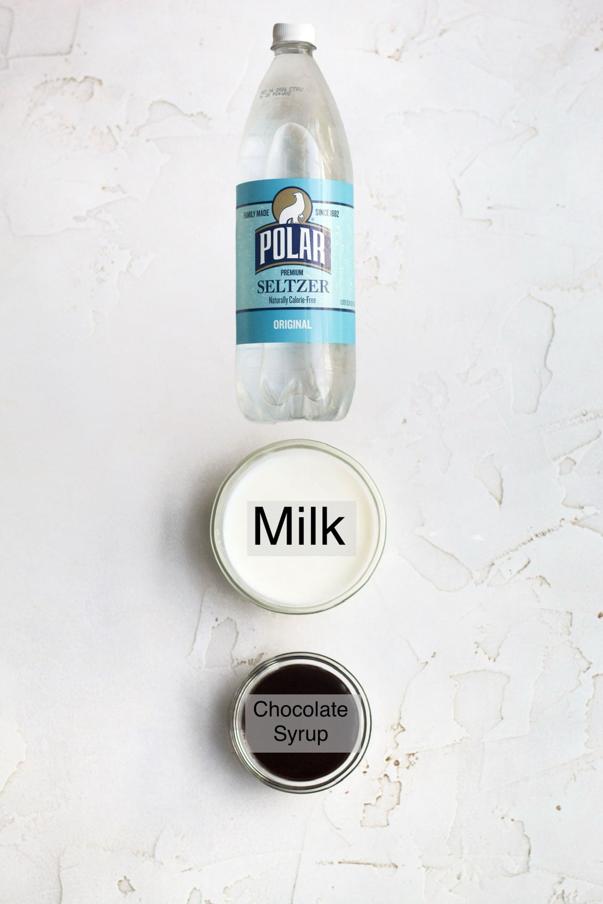 Chocolate Egg Cream Ingredients in separate containers: seltzer water, milk, and chocolate syrup.