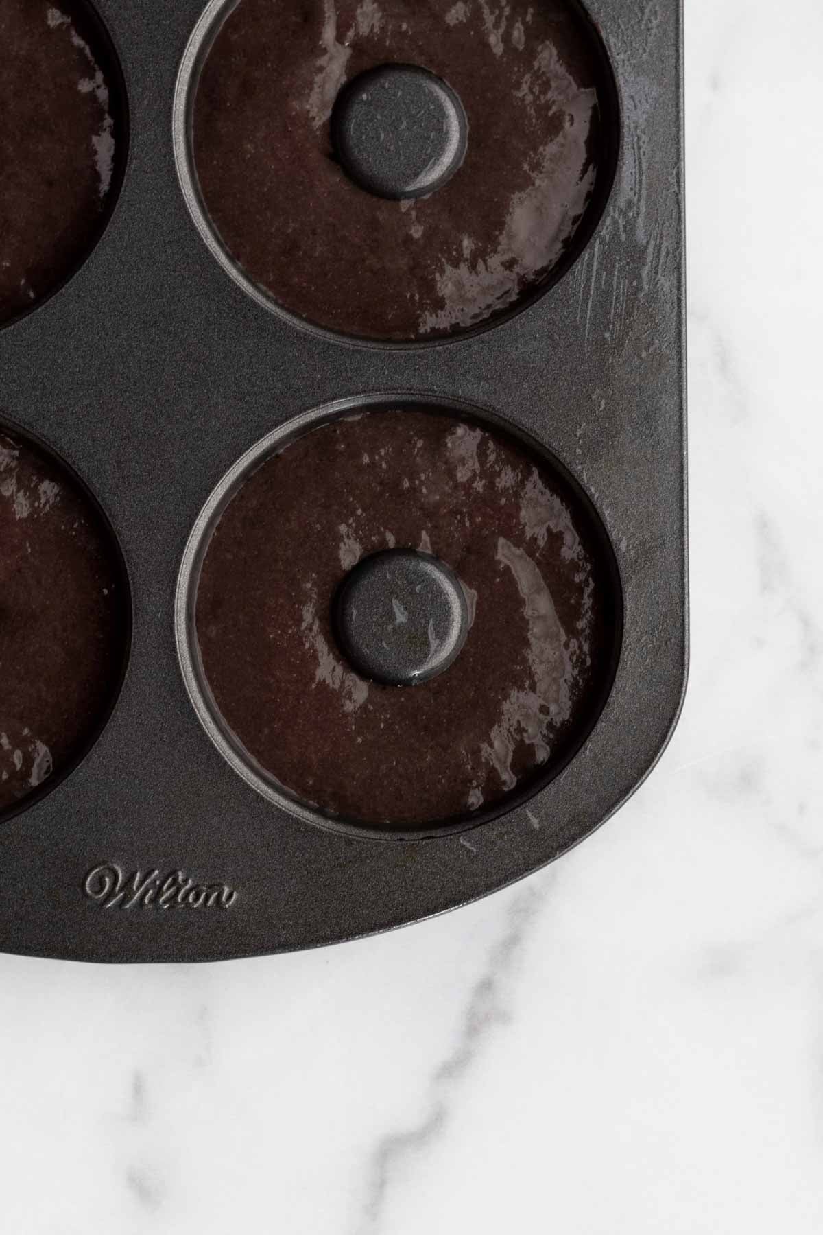 filling a donut tin with the batter.