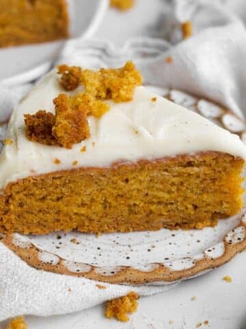 slice of moist easy carrot cake with its vibrant orange crumb and sweet cream cheese frosting.