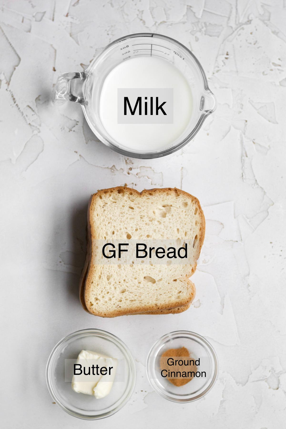 easy french toast ingredients all separated: milk, gluten free bread, butter, and ground cinnamon.