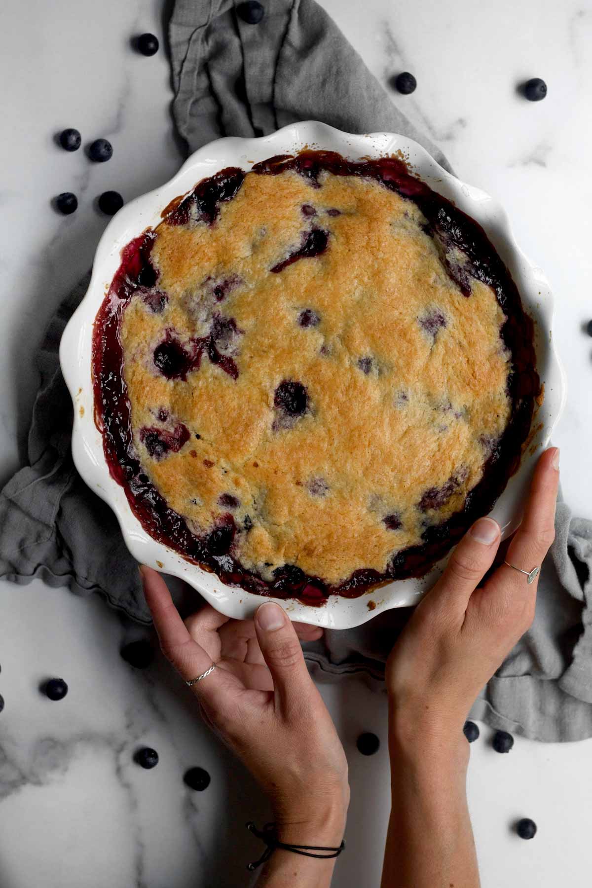 gluten-free blueberry cobbler in a baking dish with blueberries and a golden crust.