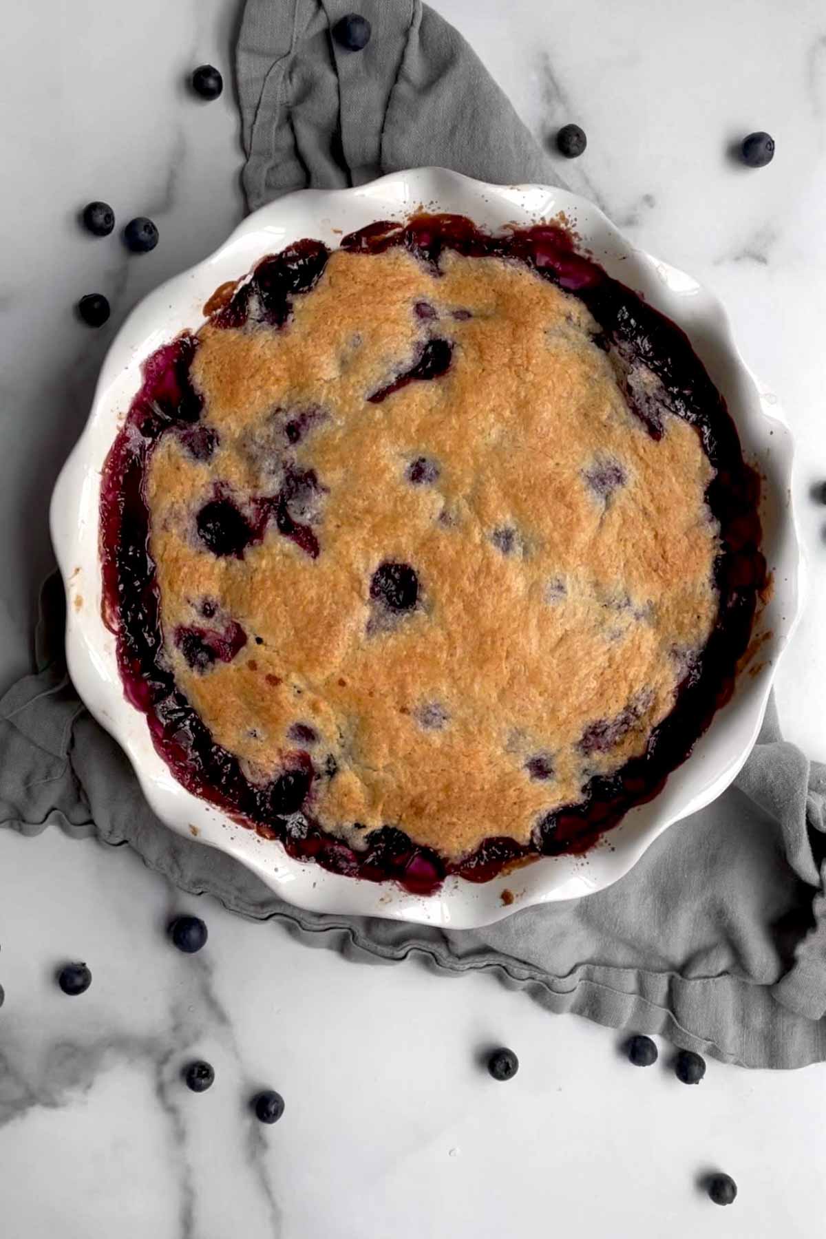 warm, golden-brown, gluten free blueberry cobbler oozing with bursted blueberries.