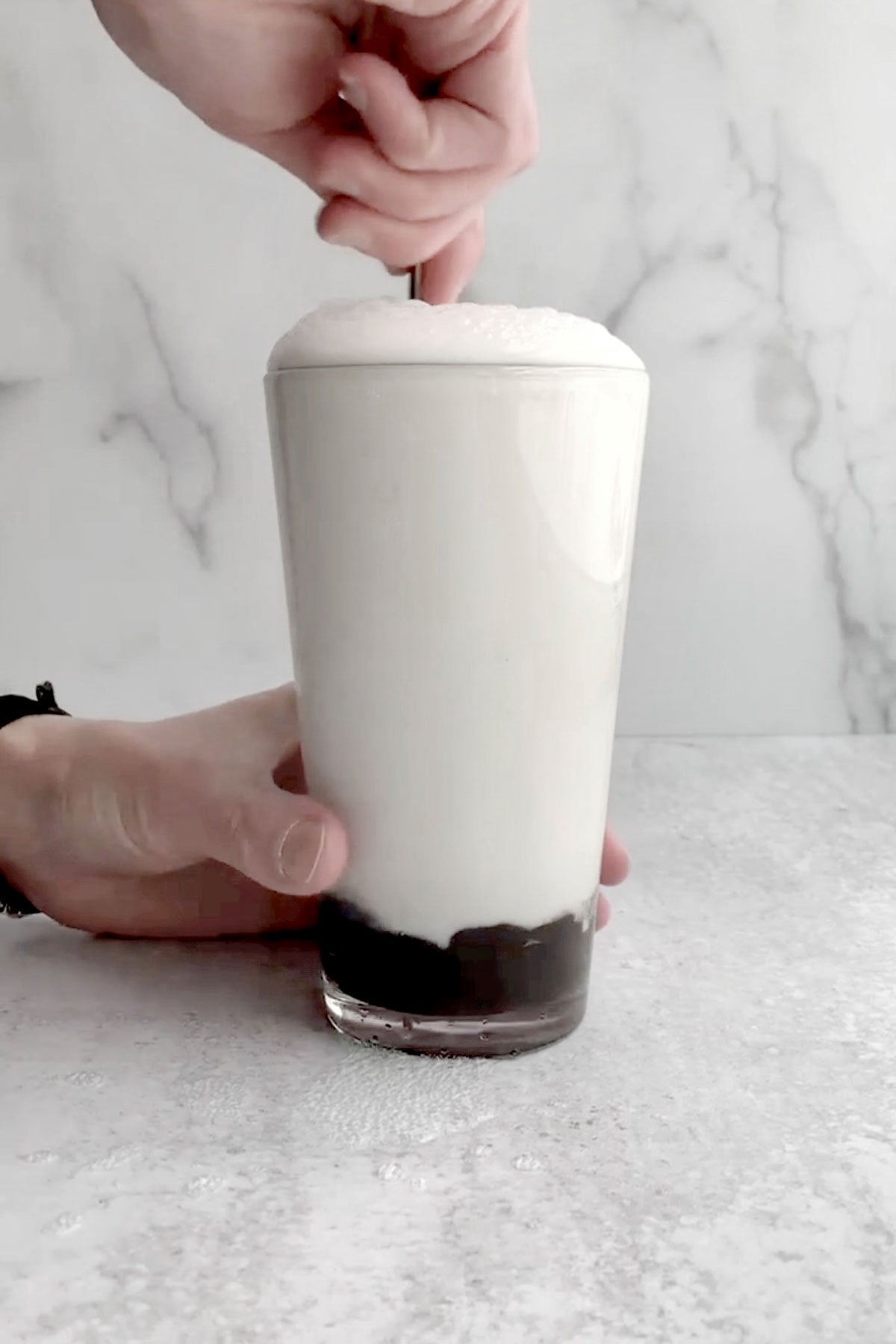 Stirring the mixture aggressively to make it bubble.