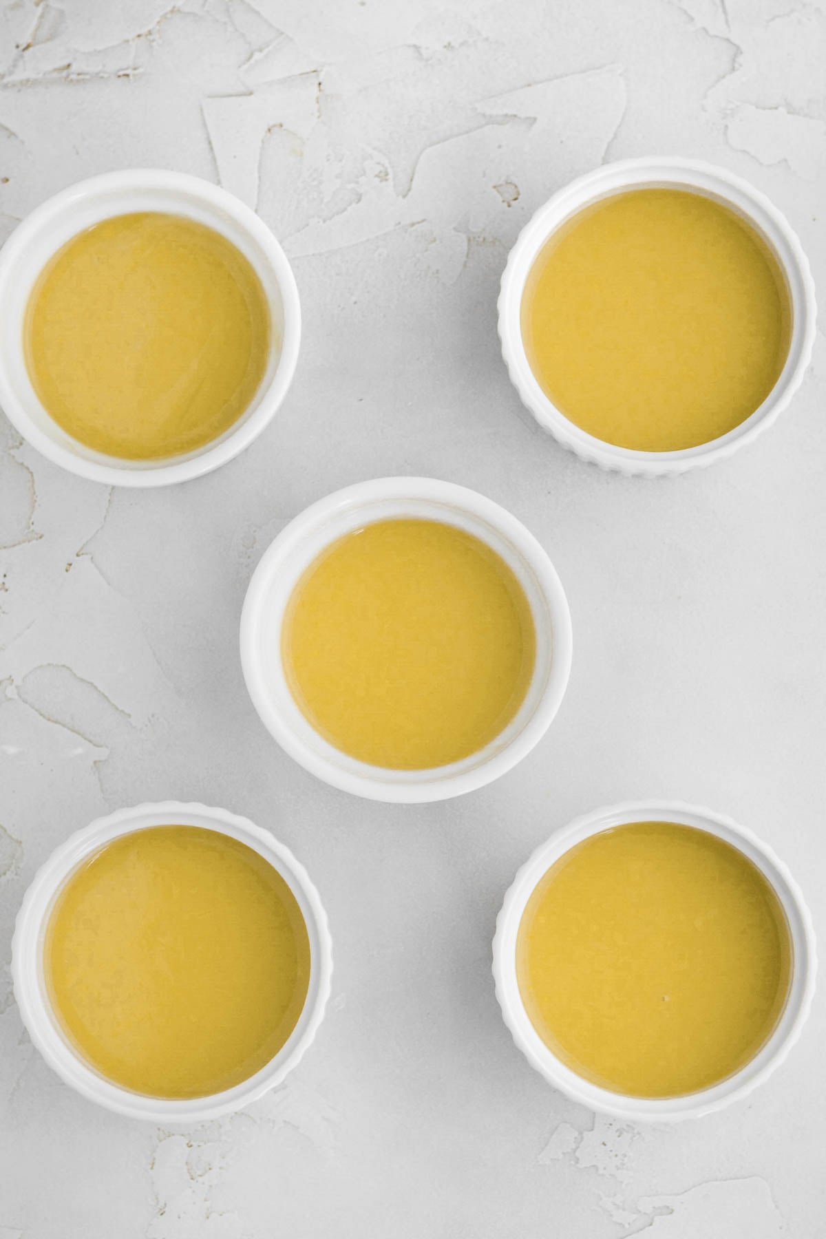 five ramekins filled with fresh orange posset.