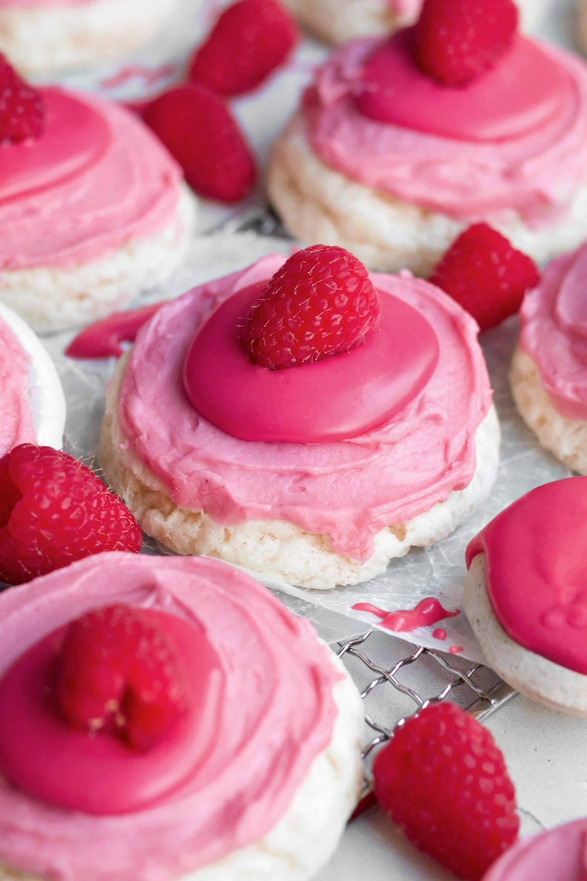raspberry cheesecake cookies topped with whole fresh raspberries, bright icing and creamy raspberry cream cheese frosting.