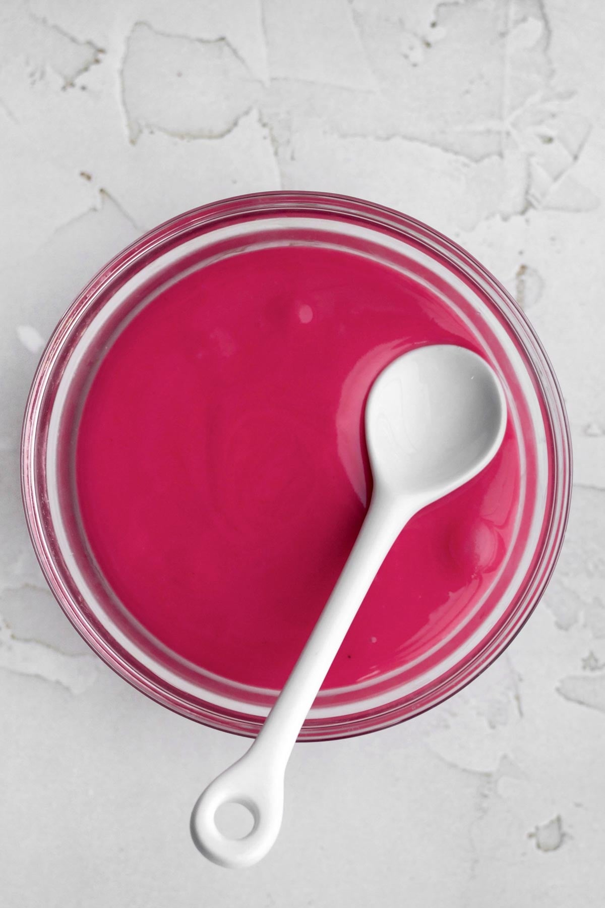 a bowl of bright and shiny magenta raspberry icing.