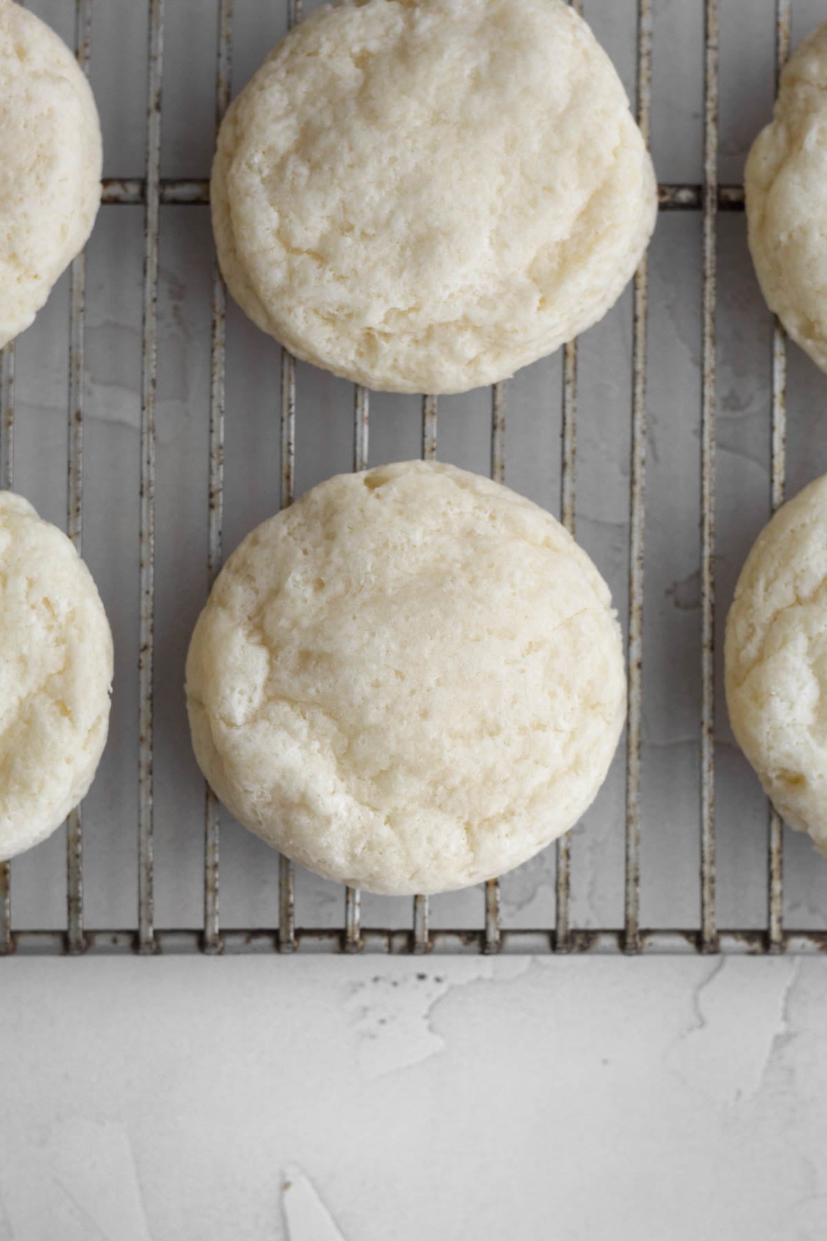fluffy and baked raspberry cheesecake cookie bases resting on a cooling rack.