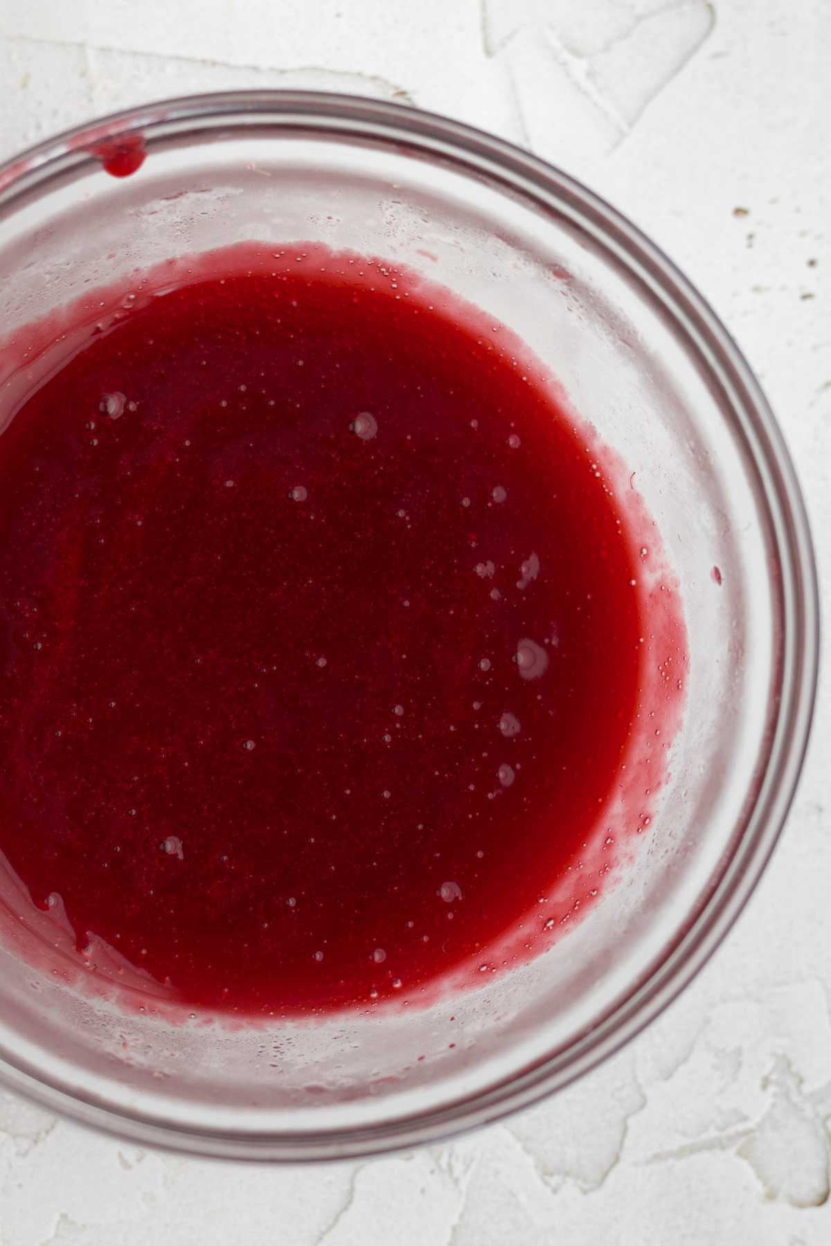 a bowl of strained red raspberry liquid.